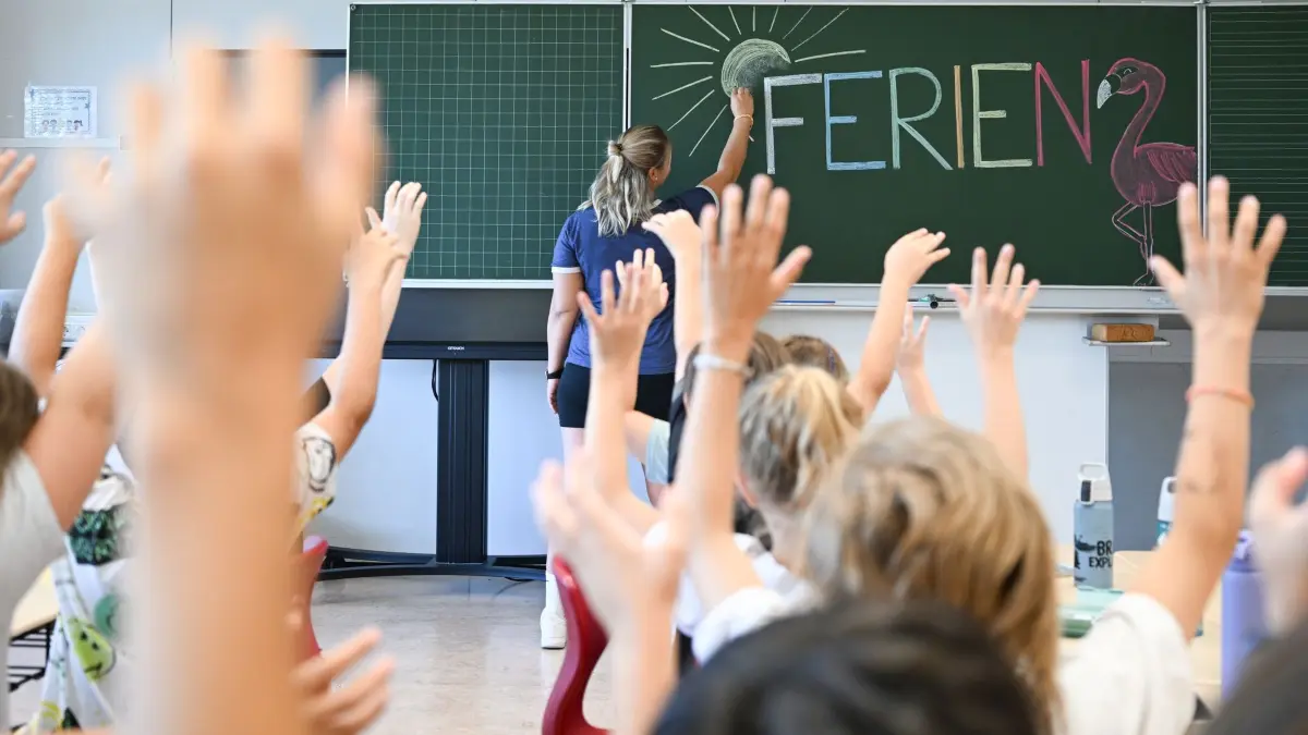 Vor Ferienbeginn in Baden-Württemberg: 28.07.2026, Baden-Württemberg, Stuttgart: Eine Lehrerin einer Grundschule schreibt in einer 4. Klasse einen Tag vor dem letzten Schultag vor den Sommerferien das Wort "Ferien" an eine Tafel (gestellte Szene). In Baden-Württemberg beginnen am 30. Juli die Schulferien. Foto: Bernd Weißbrod/dpa +++ dpa-Bildfunk +++