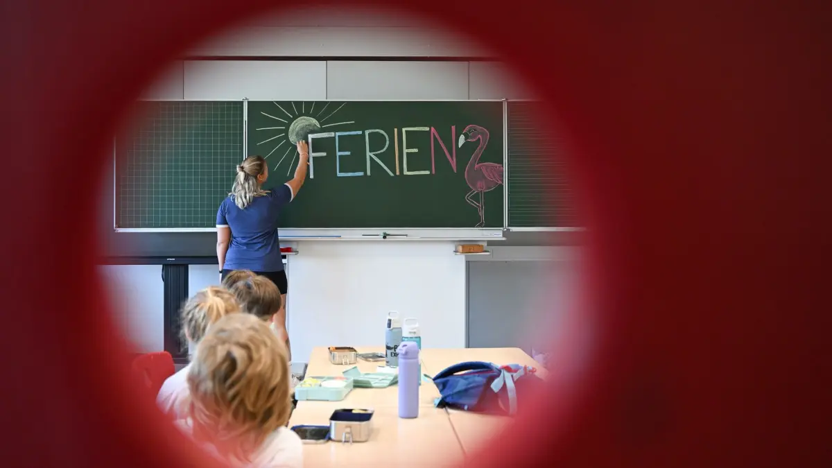 Vor Ferienbeginn in Baden-Württemberg: 28.07.2026, Baden-Württemberg, Stuttgart: Eine Lehrerin einer Grundschule schreibt in einer 4. Klasse einen Tag vor dem letzten Schultag vor den Sommerferien das Wort "Ferien" an eine Tafel (gestellte Szene). In Baden-Württemberg beginnen am 30. Juli die Schulferien. Foto: Bernd Weißbrod/dpa +++ dpa-Bildfunk +++
