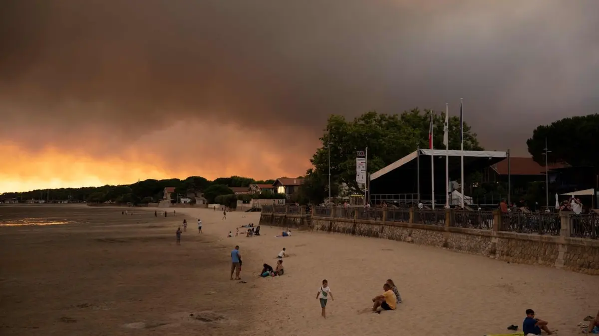 Menschen am Strand von Andernos-Les-Bains während eines Waldbrands in Lege Cap-Ferret im Südwesten Frankreichs nachdem ein Teil der umliegenden Gegend evakuiert worden war.