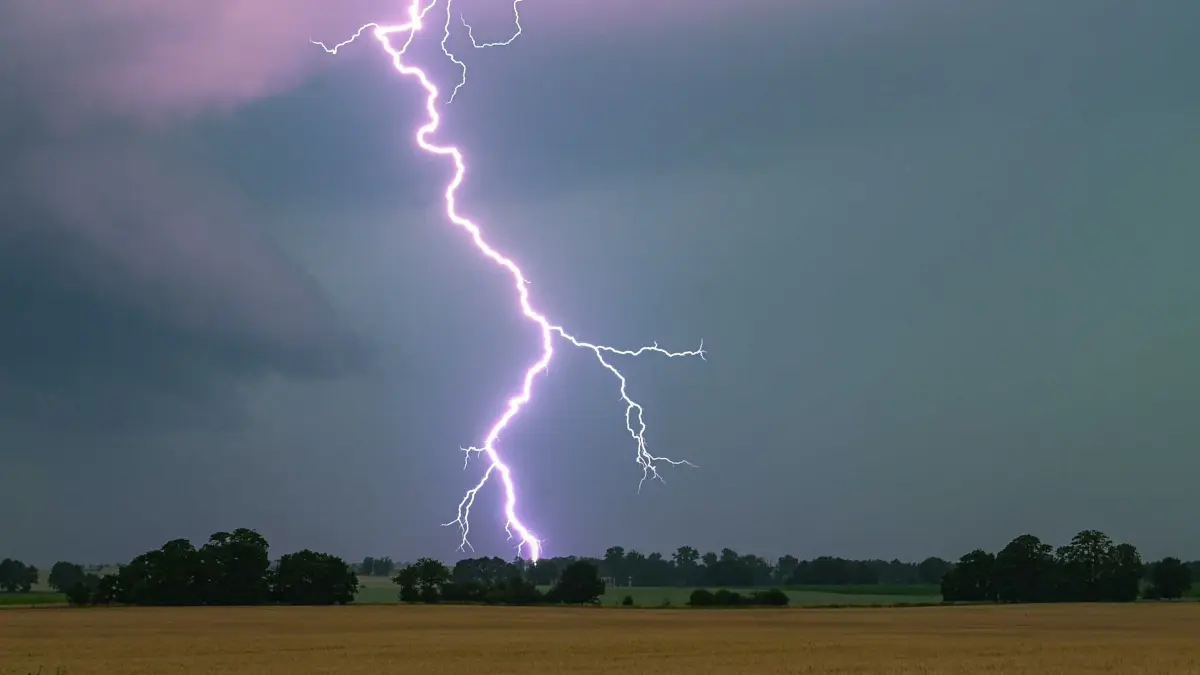 Wetter: ARCHIV - 21.06.2024, Brandenburg, Heinersdorf: Ein Blitz leuchtet über einer Landschaft auf. (zu dpa: «Sonnig, heiß und trocken, zum Abend hin Gewitter») Foto: Patrick Pleul/dpa +++ dpa-Bildfunk +++
