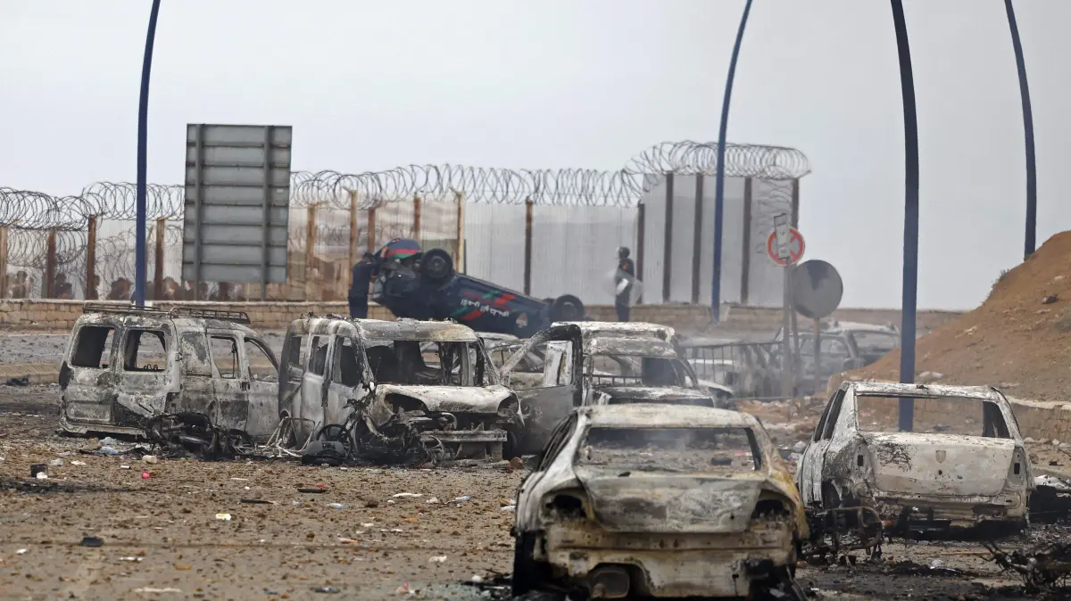 MOROCCO-SPAIN-MIGRATION: Damaged and burnt vehicles are pictured at the site of clashes near Fnideq, on the Morocco-Spain border, on July 31, 2026. Thousands of migrants crossed overnight from Morocco into Spain's north Africa's Ceuta enclave, a police source said on July 31, adding that it was impossible to estimate how many people in total. A total of 18 people died while attempting to reach the Spanish enclave, the source said. (Photo by Abdel Majid BZIOUAT / AFP)