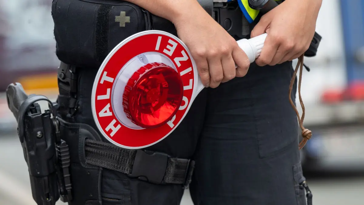 Grenzkontrollen Bundespolizei an A8: PRODUKTION - 20.08.2024, Österreich, Walserberg: Eine Polizistin steht bei Grenzkontrollen der Bundespolizei am Grenzübergang zwischen Österreich und Deutschland mit einer Polizeikelle an der Autobahn A8 nahe Salzburg (Österreich). (zu dpa: «Krise in Ceuta - Kann Spanien aus dem Schengenraum fliegen?») Foto: Peter Kneffel/dpa +++ dpa-Bildfunk +++