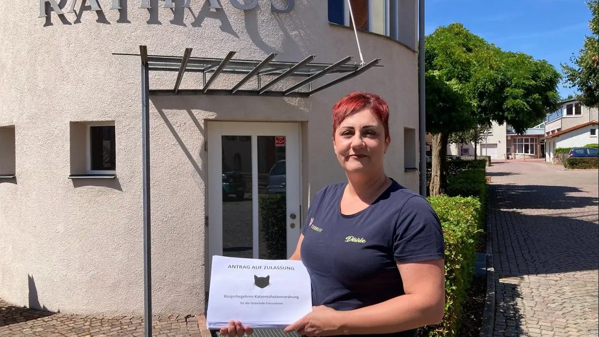 Desiree Henninger vor der Abgabe eines dicken Pakets mit Unterschriftensammlungen zum Bürgerbegehren, das den Erlass einer Katzenschutzverordnung für Friesenheim fordert.