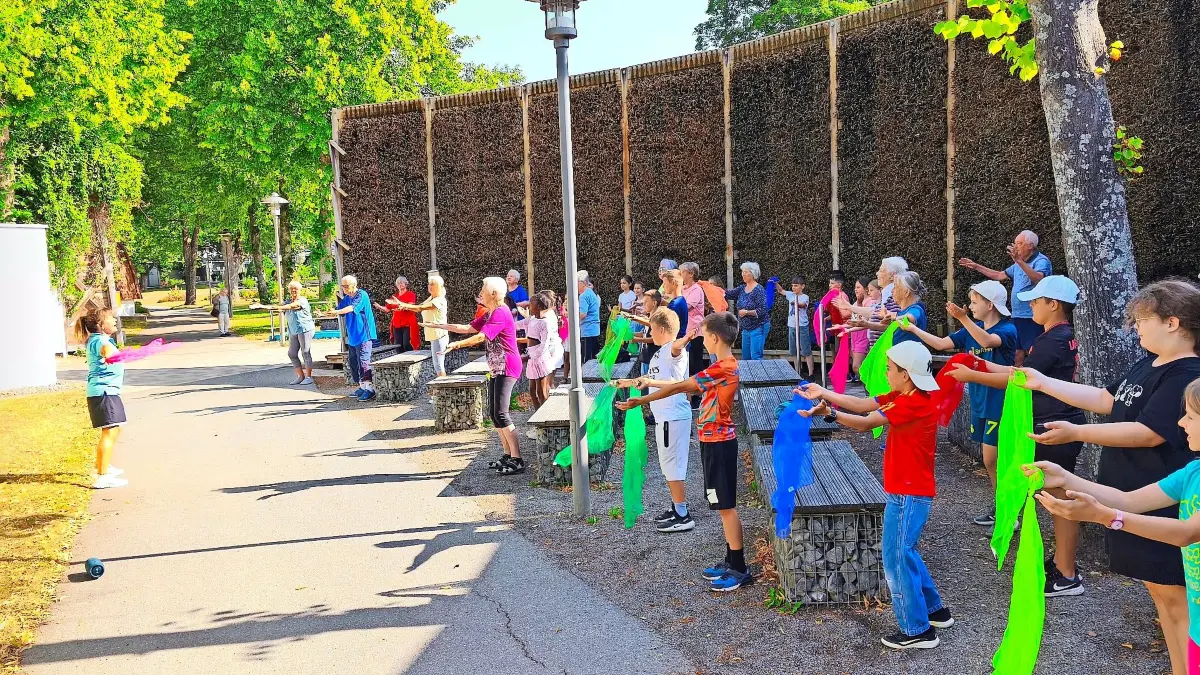 Schülerinnen und Schüler sowie Gäste haben bei der generationenübergreifenden Gymnastik am Gradierwerk sichtlich Freude.