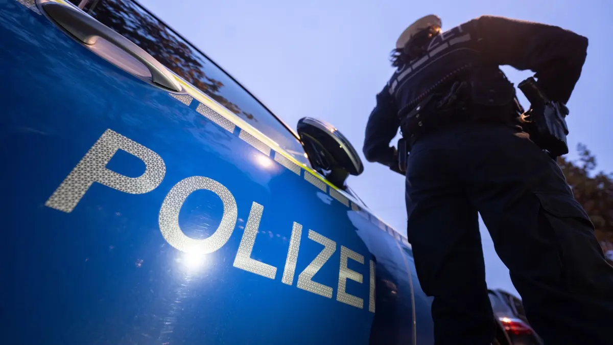 Polizei Symbolbild: ILLUSTRATION - 30.11.2023, Baden-Württemberg, Stuttgart: Eine Polizistin steht neben einem Polizeifahrzeug. (zu dpa: «Mann richtet Schusswaffe auf Streifenwagen und flüchtet») Foto: Marijan Murat/dpa +++ dpa-Bildfunk +++