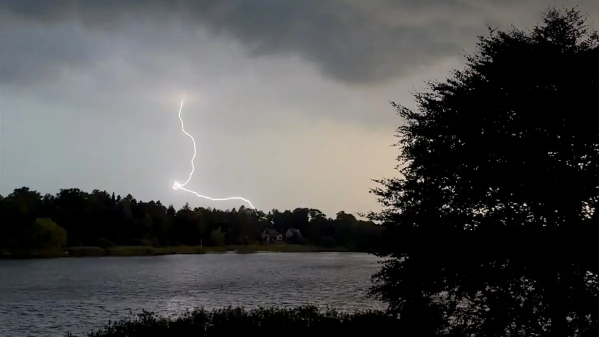 Unwetter in Schleswig-Holstein: ARCHIV - 27.06.2026, Schleswig-Holstein, Kosel: Ein Blitz zuckt während eines Unwetters über dem Langsee in der Nähe von Eckernförde. Nach den hochsommerlichen Temperaturen vom Tag hat ein Gewitter mit Starkregen und Sturm am Abend für Abkühlung gesorgt. (zu dpa: «Der Regen lässt nur zwischenzeitlich nach») Foto: Daniel Bockwoldt/dpa +++ dpa-Bildfunk +++