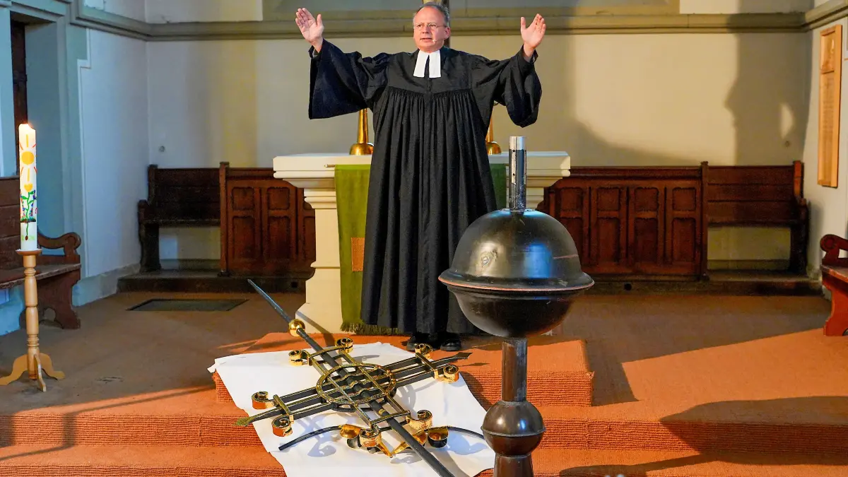 Pfarrer Christoph Kirn segnet am Ende des Gottesdienstes Turmkreuz und Turmkugel