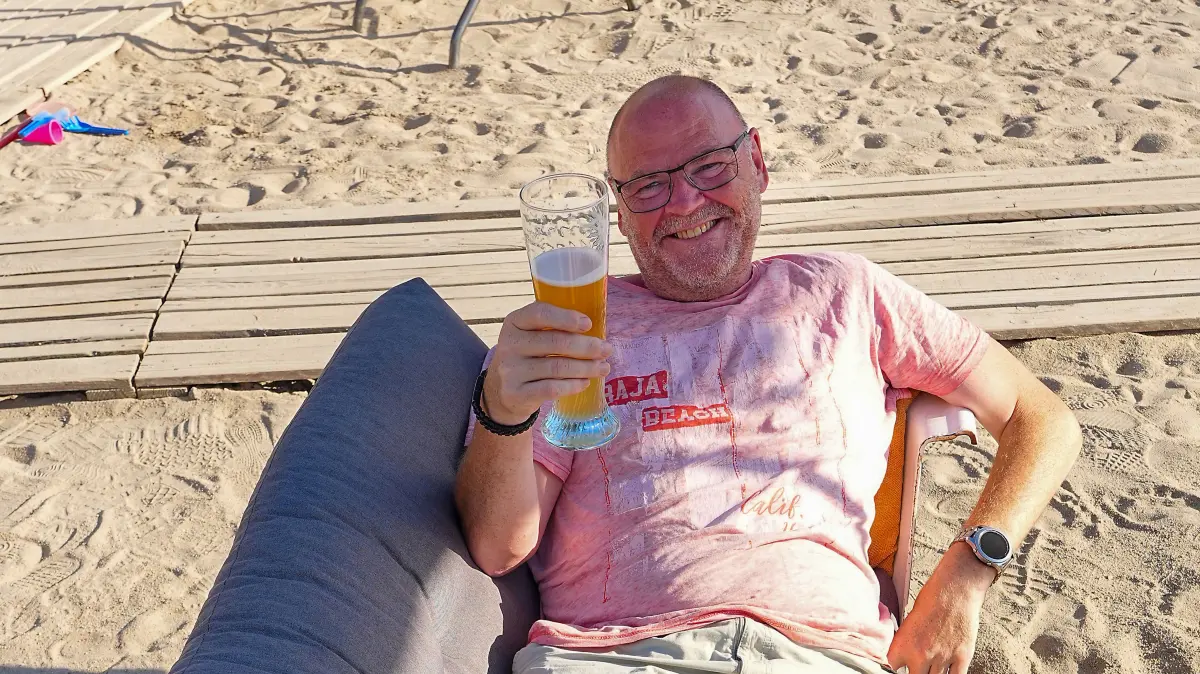Völlig gechillt liegt dieser Herr in einer Sitzbadewanne und genießt sein Bier und die Atmosphäre