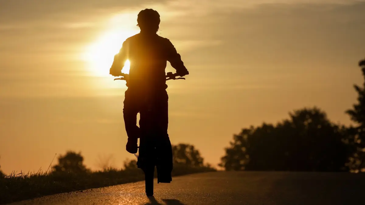 Wetter in Baden-Württemberg: 09.08.2026, Baden-Württemberg, Uttenweiler: Eine Radfahrerin ist am Morgen im Sonnenaufgang unterwegs. Foto: Thomas Warnack/dpa +++ dpa-Bildfunk +++