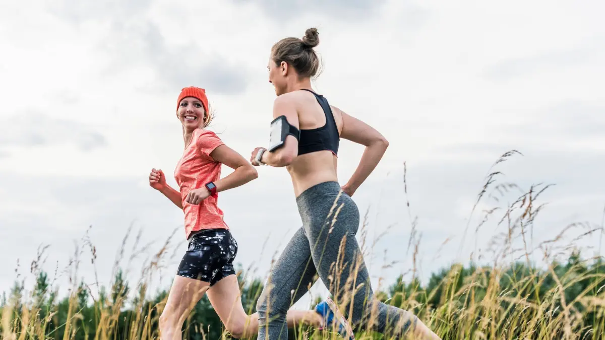 Zwei Frauen joggen gemeinsam: ILLUSTRATION - Ein Stirnband beim Joggen saugt nicht nur Schweiß auf, der dem Hörsystem schaden kann, sondern hält das Gerät auch an Ort und Stelle. (zu dpa: «Sport mit Hörgerät: Worauf sollte ich achten?») Foto: Uwe Umstätter/Westend61/dpa-tmn - ACHTUNG: Nur zur redaktionellen Verwendung im Zusammenhang mit dem genannten Text und nur bei vollständiger Nennung des vorstehenden Credits - Honorarfrei nur für Bezieher des dpa-Themendienstes +++ dpa-Themendienst +++