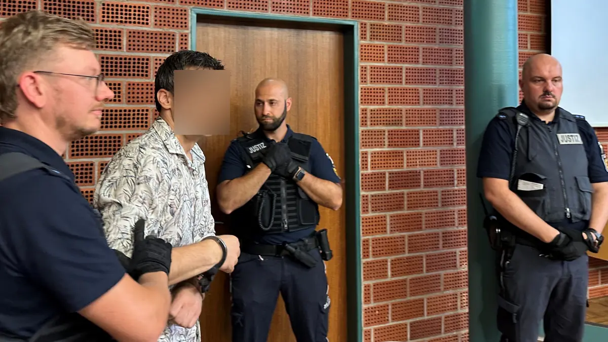 Der Bandenchef wird ein letztes Mal in diesem Prozess in den Gerichtssaal geführt. Im Zuschauerraum sitzt seine Frau und weint.