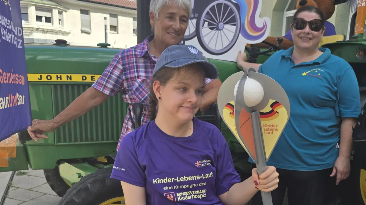 Lea hat die Fackel im Griff - und Cornelia Suhm, die spontan als freiwillige Helferin zu der Aktion dazukam, freut sich seht mit ihr und hat sie gerne zu der Aktion auf dem Marktplatz begleitet.