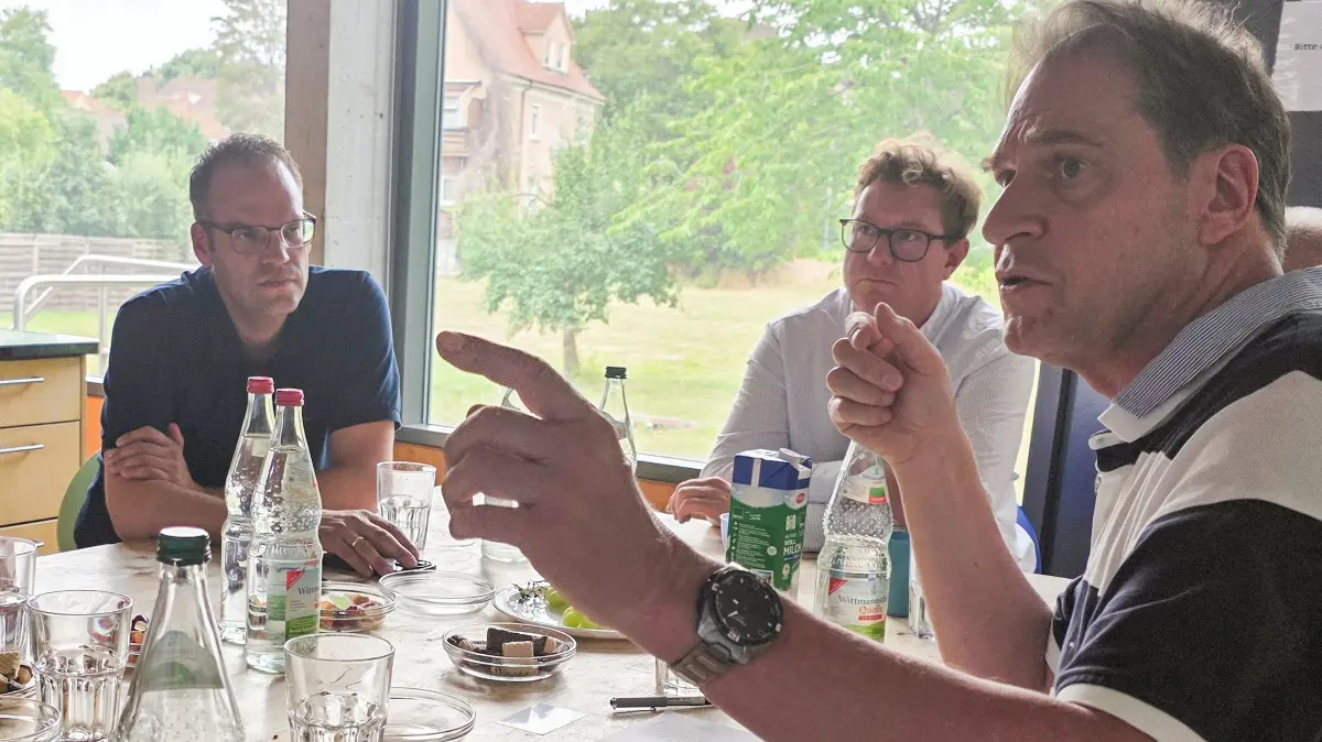 Vorstandssprecher Markus Seidel (rechts) erläutert gemeinsam mit Tomi Czech (zweiter von rechts) für Andreas Braun (links) die Daten rund um die Off Road Kids Stiftung.