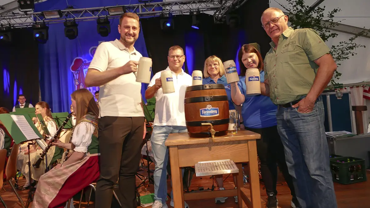 Mit zwei Schlägen eröffnet Bürgermeister Patrick Haas (von links) das Bergfest. Ortsvorsteher Volker Gut, Michaela Hall und Melanie Vollmer von der Musikkapelle sowie Brauerei-Vertreter Artur Welte freuen sich mit ihm.