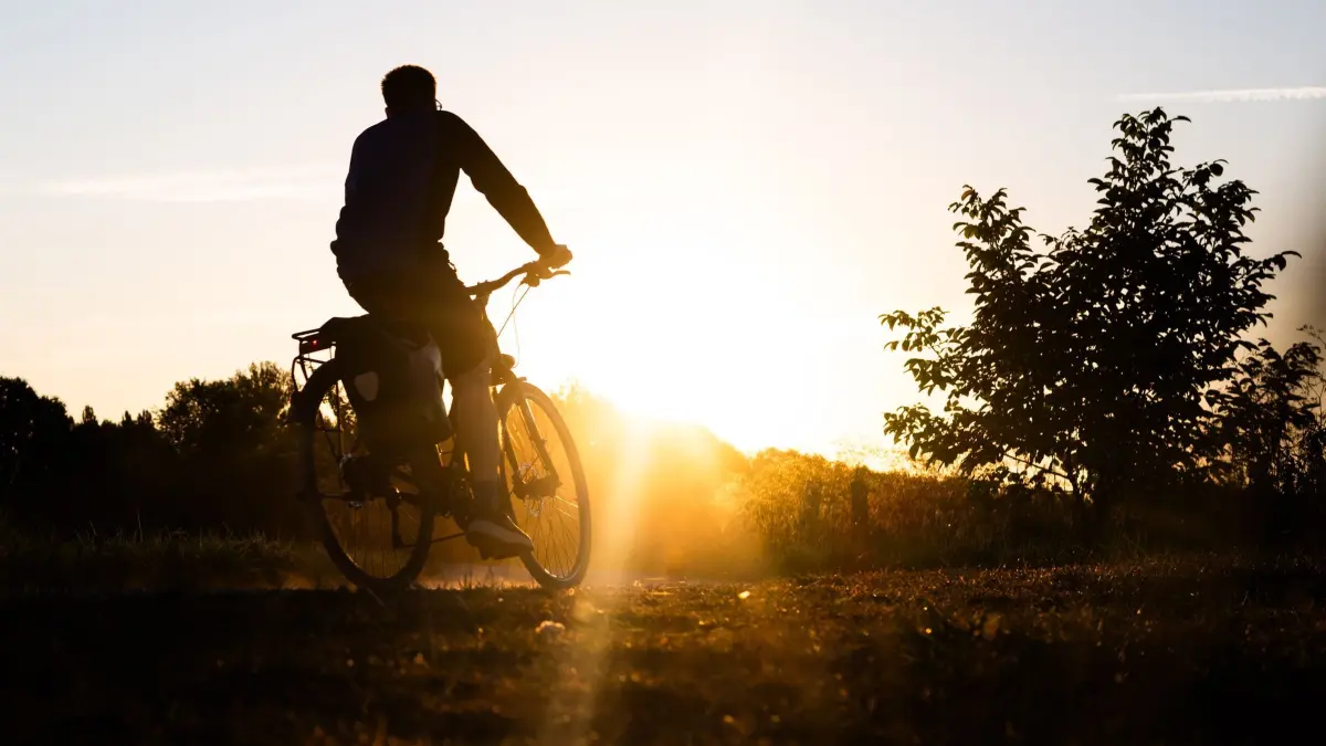 Wetter in Niedersachsen: 14.08.2026, Niedersachsen, Laatzen: Ein Radfahrer fährt bei Sonnenaufgang durch die Leinemasch. Der Deutsche Wetterdienst (DWD) sagt auch für die Region Hannover sehr heißes Wetter voraus. Foto: Julian Stratenschulte/dpa +++ dpa-Bildfunk +++