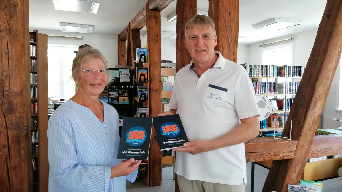Michael Widmann übergibt zwei seiner Werke als Spende an Antje Hartmann für die Stadtbücherei Neubulach.
