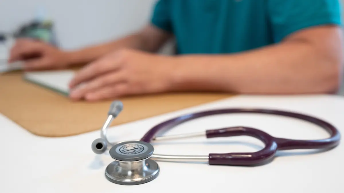 Ein Hausarzt sitzt in einem Sprechzimmer. Die Gesundheitsreform belastet die Arztpraxen, kritisieren auch zwei Hausärzte aus Brigachtal und schreiben einen Brandbrief. Werden sie gehört? (Symbolbild)