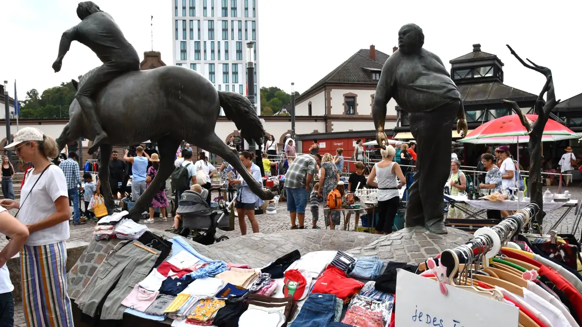 Vertraute Szenerie: Einmal im Monat findet auf den Plätzen von Post und Rathaus der Lörracher Flohmarkt statt. Der Heiner und der Brassenheimer Müller schauen stoisch zu.