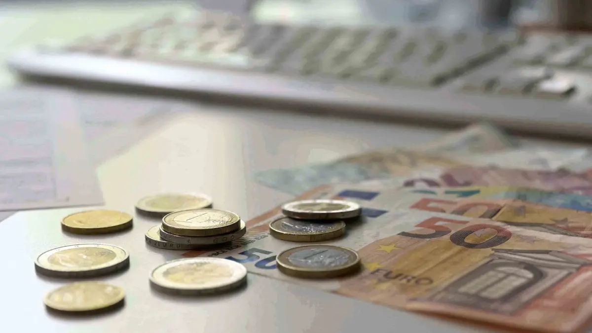 Geld: ILLUSTRATION - 07.05.2026, Bayern, München: Euro-Banknoten und -Münzen liegen auf einem Tisch vor einer Computertastatur. (zu dpa: «Wofür Bayern ihr Geld ausgeben») Foto: Malin Wunderlich/dpa +++ dpa-Bildfunk +++