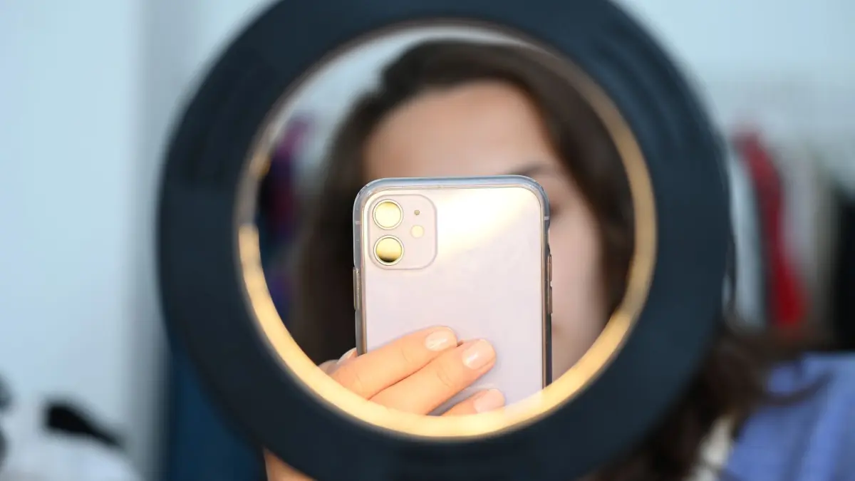 Influencer sitzt mit dem Smartphone hinter einem Ringlicht: ILLUSTRATION - Auf vertrauenswürdige Accounts achten: Zu Medfluencern gehören echte Experten wie Ärzte oder Pflegekräfte - aber auch fachfremde Laien. (zu dpa: «Gesundheitsinfluencer - wer ist seriös?») Foto: Niklas Graeber/dpa/dpa-mag - Honorarfrei nur für Bezieher des Dienstes dpa-Magazin +++ dpa-Magazin +++