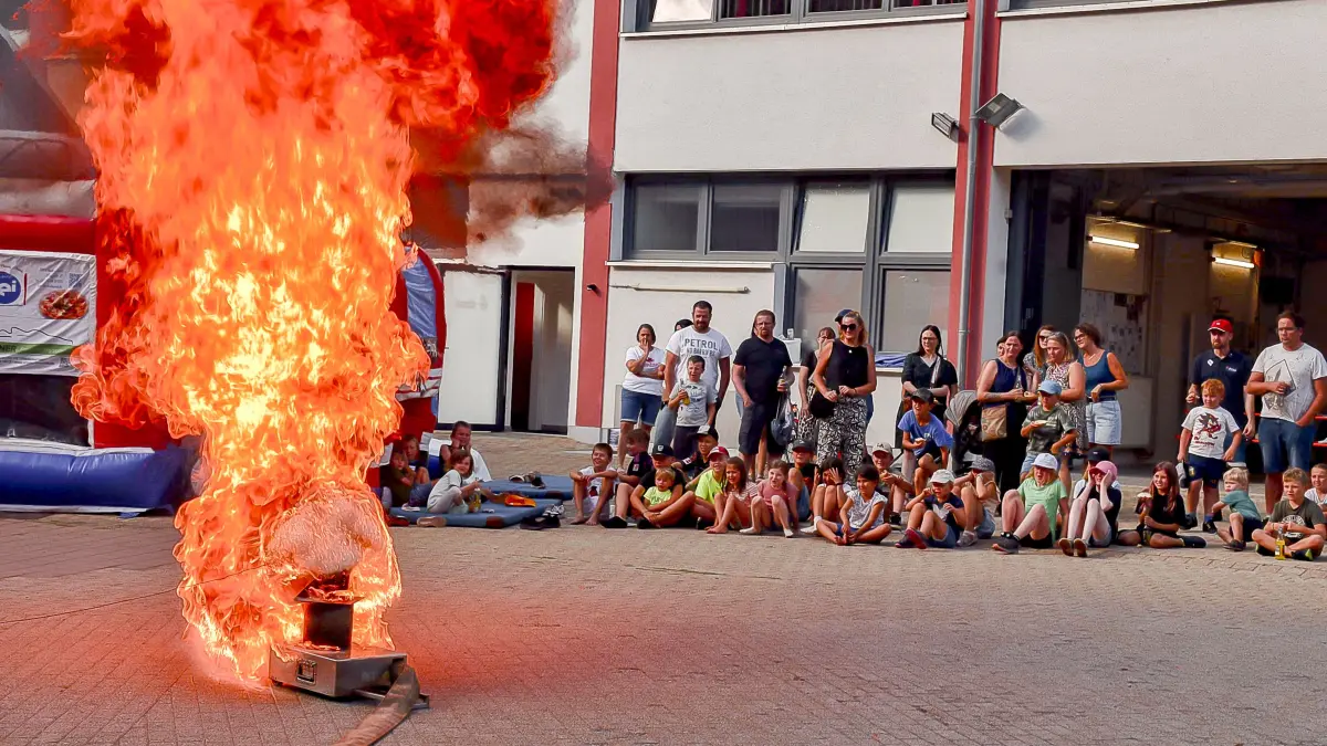 Beim Kinderferienprogramm in Fischbach zeigte die Feuerwehr den Kindern, wie eine Fettexplosion ablaufen kann. Die schauten gebannt auf das Spekatkel.