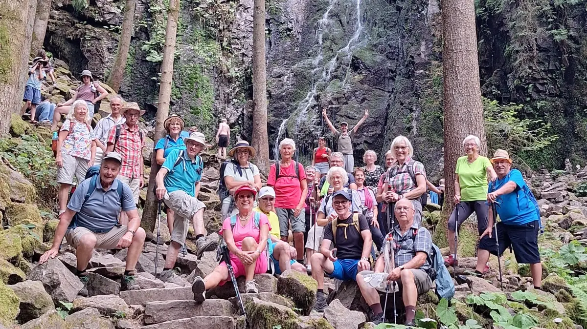 Die Teilnehmer mit dem Wasserfall im Hintergrund