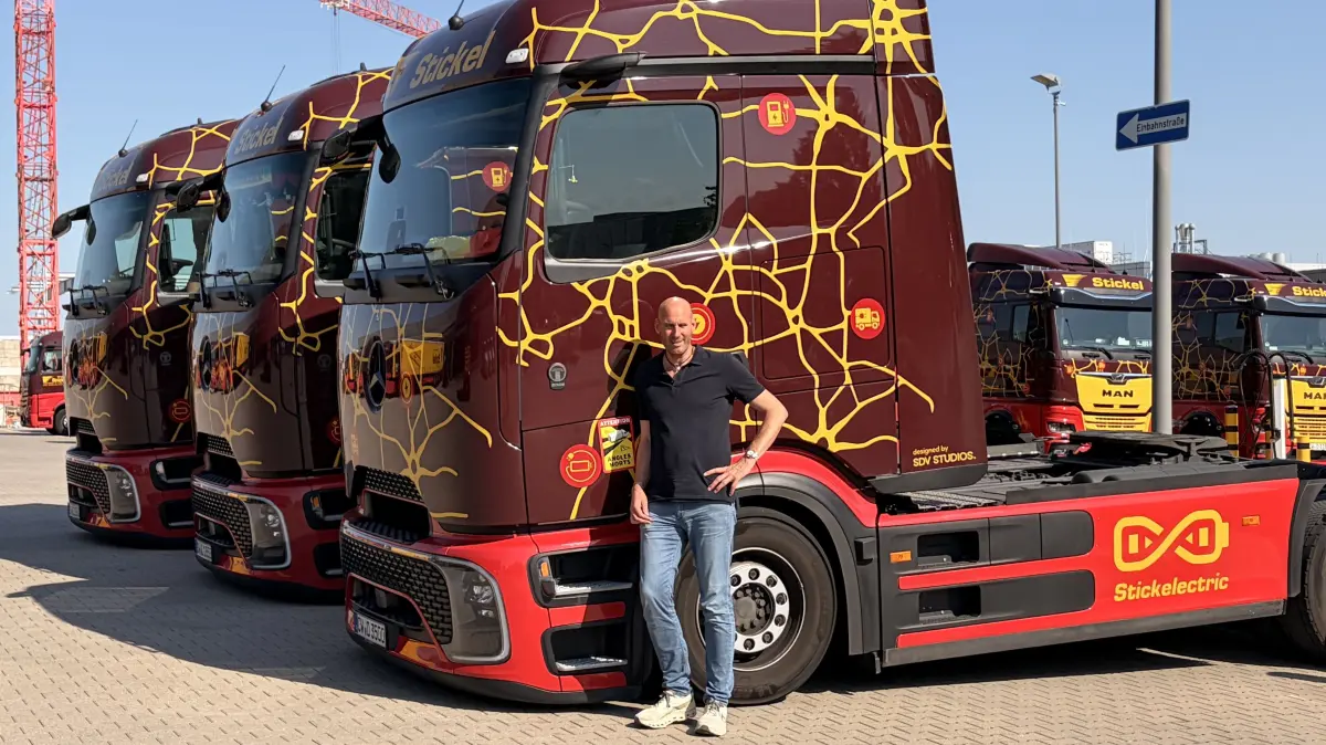 Chef Christian Stickel vor einem für seine E-Laster typisch lackierten E-Fahrzeuge.