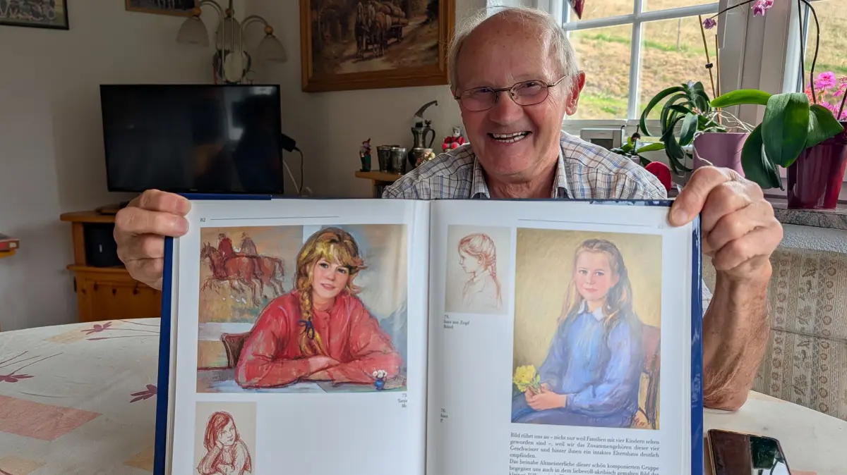 Roland Dufner präsentiert Stolz einen Bildban über Waltraud Oloff.