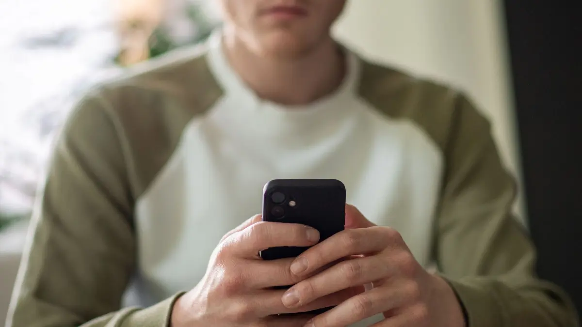 Ein junger Mann tippt auf seinem Handy: ILLUSTRATION - Gerade online sind die Hürden, einem extremen Shoppingdrang nachzugehen, oft sehr niedrig. (zu dpa: «Kaufsucht: Warum der schnelle Klick gefährlich werden kann») Foto: Zacharie Scheurer/dpa-tmn - Honorarfrei nur für Bezieher des dpa-Themendienstes +++ dpa-Themendienst +++