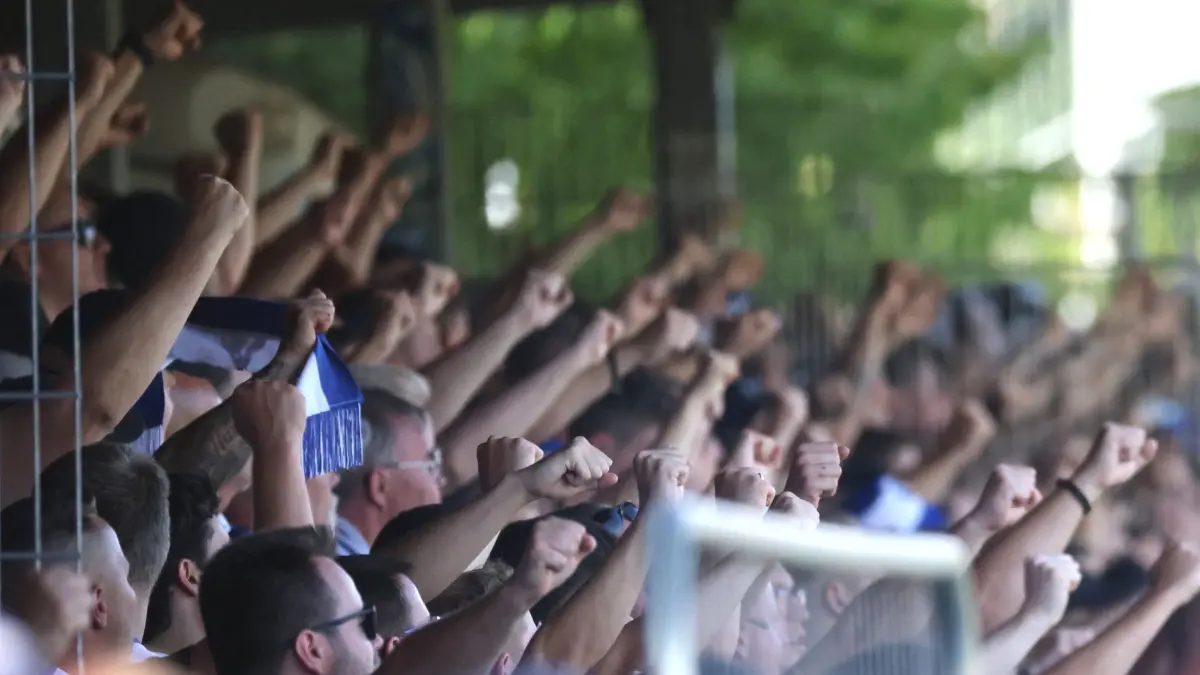 Bahlinger SC - 1. FC Magdeburg: 23.08.2026, Baden-Württemberg, Bahlingen am Kaiserstuhl: Fußball, Männer: DFB-Pokal, Bahlinger SC - 1. FC Magdeburg, 1. Runde, im Kaiserstuhlstadion, Fans von Magdeburg auf der Tribüne. Foto: Philipp von Ditfurth/dpa - WICHTIGER HINWEIS: Gemäß den Vorgaben der Bundesliga bzw. des DFB Deutscher Fußball-Bund ist es untersagt, in dem Stadion und/oder vom Spiel angefertigte Fotoaufnahmen in Form von Sequenzbildern und/oder videoähnlichen Fotostrecken zu verwerten bzw. verwerten zu lassen. +++ dpa-Bildfunk +++