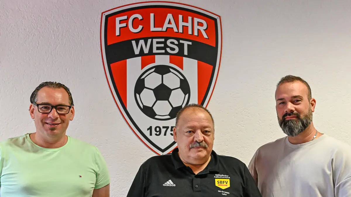 Trainer und Mitglieder des Vorstandes des FC Lahr-West stellen die Situation zwei Jahre nach der Fast-Auflösung vor (von links): Trainer Alexandro Roccaro, Bruno Galan und Tayfun Kitapci (derzeit Beisitzer im Vorstand). An der Wand ist das neue Logo, ein Symbol für den Neustart, zu sehen.