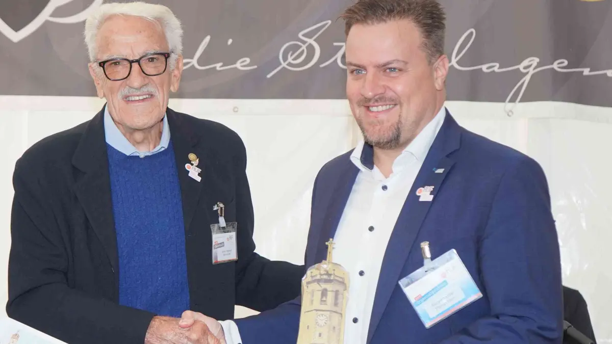Als Gruß überreicht Josep Vilanova, Präsident der Vereinigung „Feria de reloj de Catalunya“ aus Sant Feliu in Spanien, Florian Merz das Modell des sanierten Glockenturms der Kirche Sant Feliu.