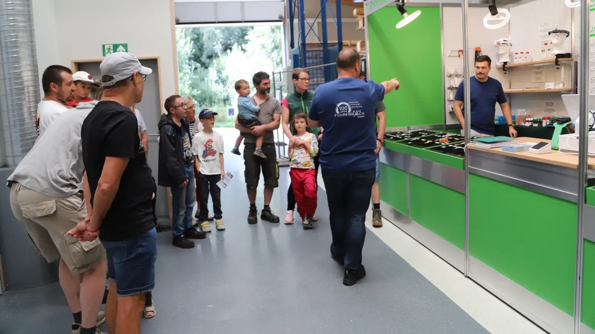 Fabian Fehrenbach (rechts) führt ein gutes Dutzend Besucherinnen und Besucher anlässlich des Tages der offenen Tür durch die Produktion.
