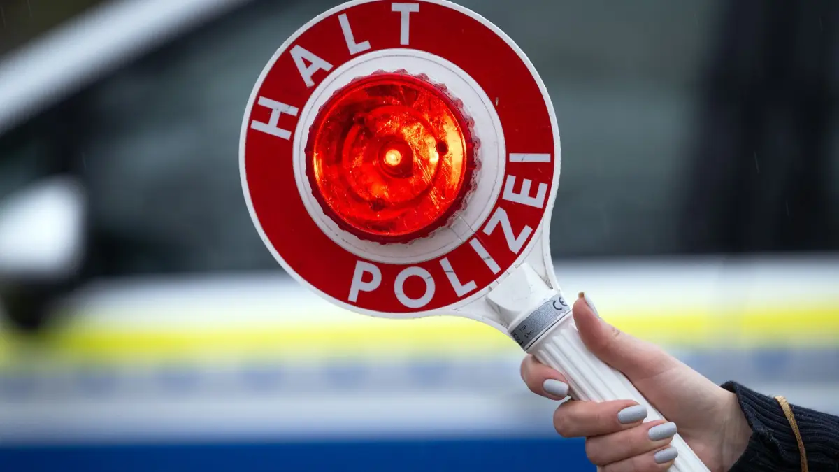 Verkehrskontrolle: ARCHIV - 22.03.2024, Brandenburg, Trebbin: Eine Polizistin hält während einer Verkehrskontrolle eine Polizeikelle mit der Aufschrift „Halt Polizei“. (Symbolbild) (zu dpa: «Autofahrer flüchtet mit bis zu 180 km/h vor Polizei») Foto: Soeren Stache/dpa +++ dpa-Bildfunk +++
