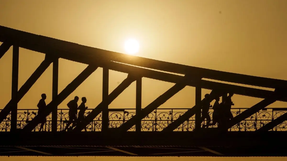 Frankfurt am Main: Eine Gruppe joggt bei Sonnenaufgang über den Eisernen Steg.