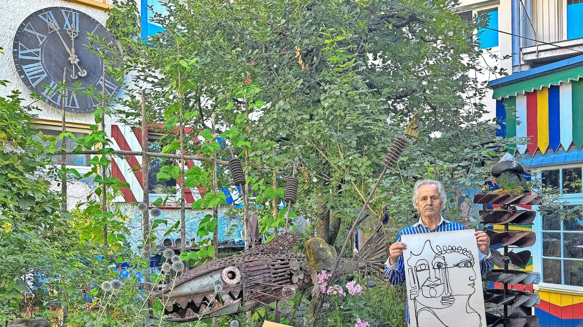 Rolf Karl zeigt im Hinterhof des Anwesens – einem wahren Kleinod – Zeichnungen seines Schwiegervaters. Links ist das ehemalige Zifferblatt der Dögginger Kirche zu sehen.