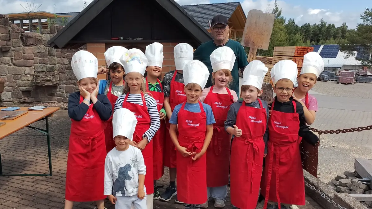 Die jungen Ferienbäcker und -bäckerinnen vor dem großen Holzbackofen.