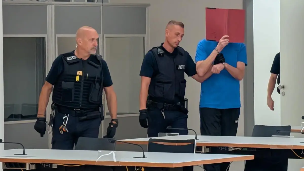 Justizbeamte führen den Angeklagten am Tag der Urteilsverkündung in den Gerichtssaal.