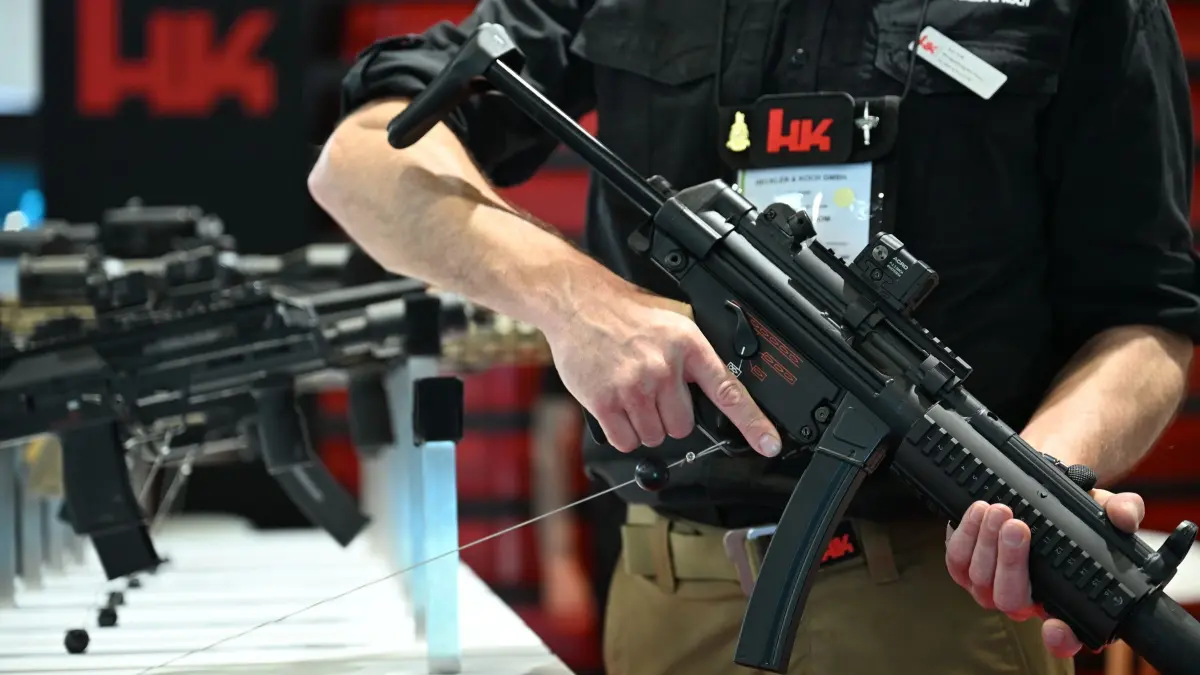 Heckler & Koch: ARCHIV - 15.06.2026, Frankreich, Paris: Bei der Rüstungsmesse Eurosatory steht ein Mitarbeiter von Heckler & Koch beim Messestand seiner Firma und hält eine Maschinenpistole in der Hand. Im Hintergrund sind weitere Maschinenpistolen zu sehen. Die Firma hat Umsatz und Gewinn im ersten Halbjahr 2026 deutlich steigern können. (zu dpa: «Heckler & Koch macht so viel Gewinn wie noch nie») Foto: Wolf von Dewitz/dpa +++ dpa-Bildfunk +++