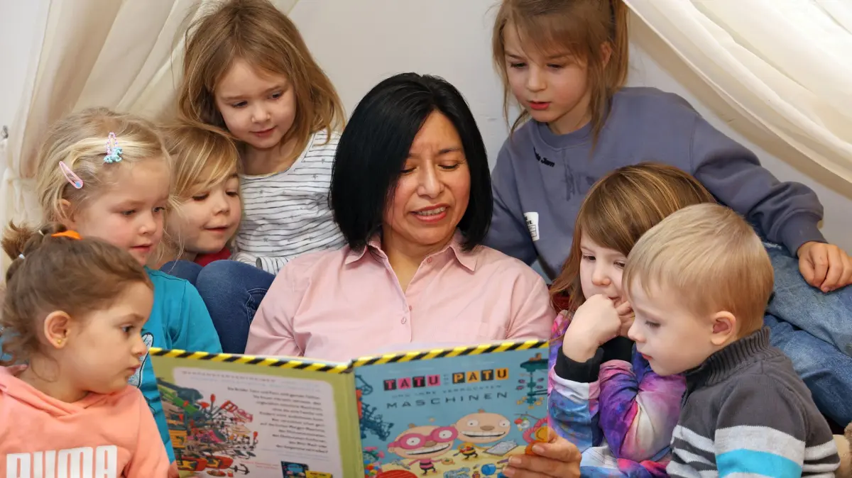 Regierung bringt bundesweite Kita-Standards auf den Weg: Elizabeth Yesenia Peimann liest in der Kita der evangelischen St.-Georgs-Gemeinde in Bremen-Huchting den Kindern ein Buch vor (Foto vom 12.03.2024). Die Bundesregierung will die Betreuung und Foerderung in Kitas staerker standardisieren und den Entwicklungsstand der Kinder besser erfassen. Kuenftig sollen bei allen Vierjaehrigen die Sprachentwicklung und weitere Faehigkeiten dokumentiert werden, wie das Bundeskabinett am Mittwoch, 02.09.2026, auf Initiative des Bundesfamilienministeriums beschloss. Wenn sich dabei Defizite zeigen, sollen entsprechende Foerdermassnahmen folgen. (Siehe epd-Meldung vom 02.09.2026) *** Local Caption *** 00514189