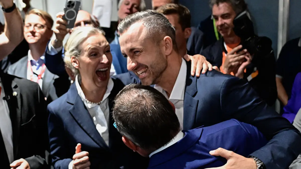GERMANY-POLITICS-VOTE-STATE-SAXONY-ANHALT: Ulrich Siegmund, top candidate in the Saxony-Anhalt state election for the far-right Alternative for Germany (AfD) party AfD's main candidate in the Saxony-Anhalt state election Ulrich Siegmund (R), co-leaders of the far-right Alternative for Germany (AfD) party Alice Weidel and co-leader of the far-right Alternative for Germany (AfD) party Tino Chrupalla celebrate and hug after exit polls following Saxony-Anhalt's state elections at the fairgrounds in Magdeburg, eastern Germany on September 6, 2026. (Photo by Tobias SCHWARZ / AFP)