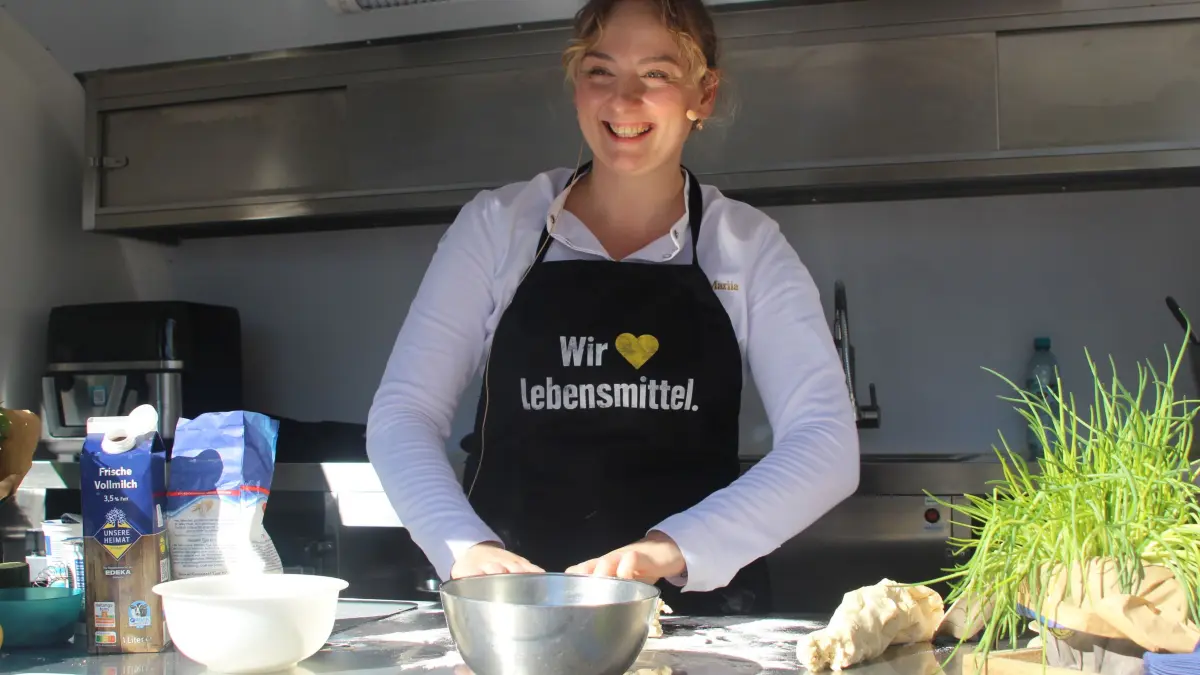 Konditorin und Köchin Mariia Serhiichuk kochte Hefeklößchen und begoss sie mit Vanillesoße.