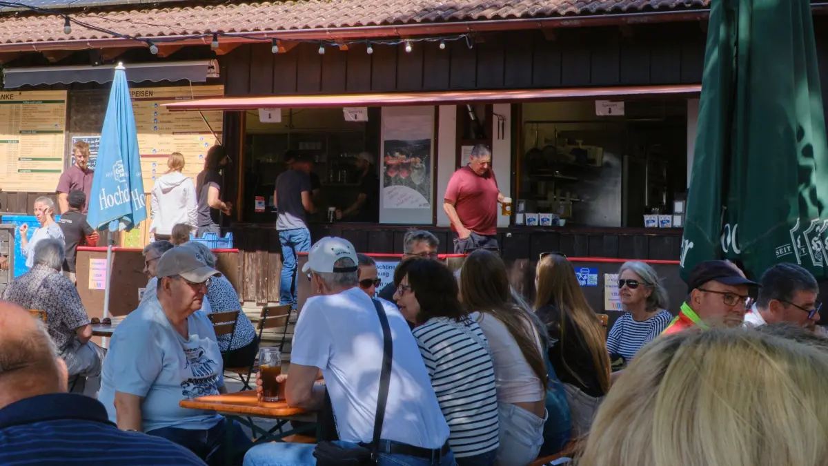 Die Tische vor der Essens- und Getränkeausgabe des Biergartens waren mit AfD-Gegnern besetzt. Sie wollten verhindern, dass Gäste angesprochen werden.