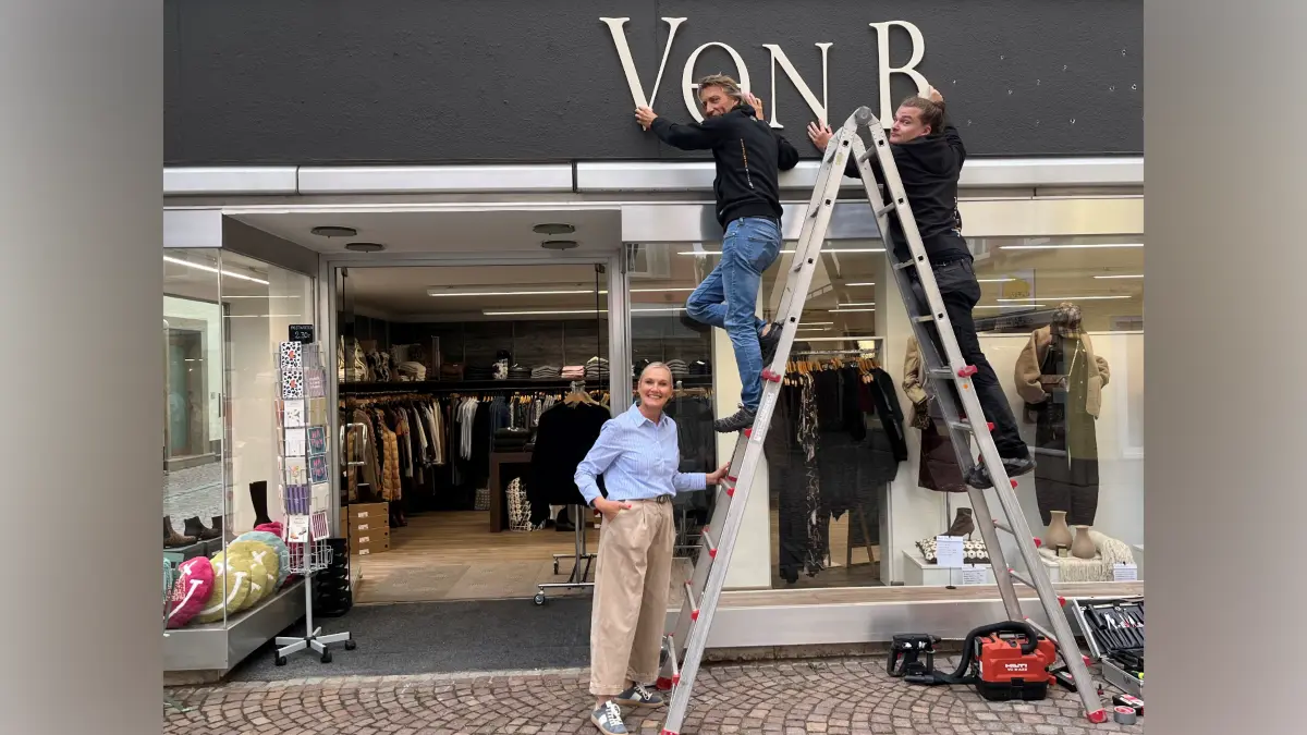 Manuela Aepfelbach, Inhaberin der Boutique Von Bora, Rottenburg. Peter Wolf (links auf der Leiter) und Michael Riehle von der Firma Hoffmann Werbetechnik, installierten am Mittwoch,9. September 2026, das neue Ladenschild.