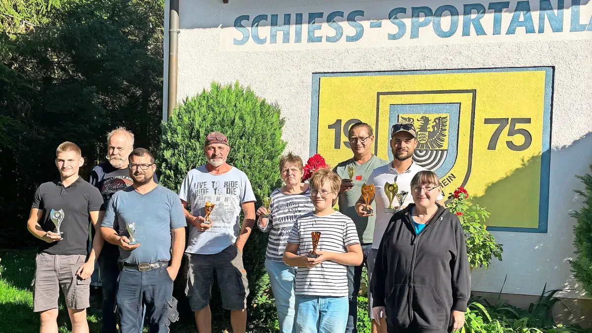 Sieger präsentieren stolz ihre Pokale.