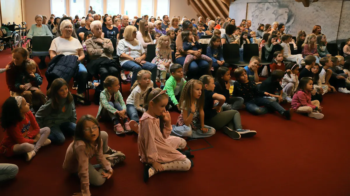 Gebannt verfolgen viele Kinder und einige Erwachsene sowohl die musikalische Darbietung als auch die Lesung von Karsten Dönneweg und die Illustrationen dazu