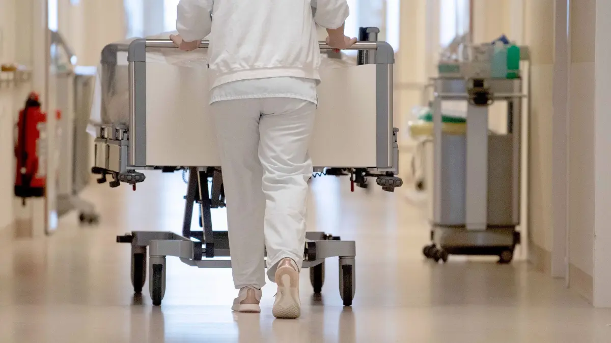Krankenhausreform in NRW: ARCHIV - 20.01.2020, Baden-Württemberg, ---: Eine Krankenpflegerin schiebt ein Krankenbett durch einen Krankenhausflur. (zu dpa: «Etwas mehr Patienten in Krankenhäusern in NRW aufgenommen») Foto: Marijan Murat/dpa +++ dpa-Bildfunk +++