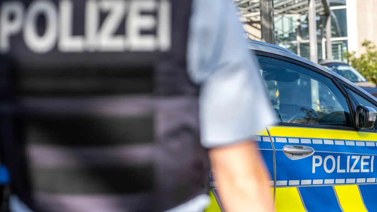 Symbolbild - Blaulicht: ILLUSTRATION - 28.09.2021, Nordrhein-Westfalen, Gütersloh: Ein Polizist steht vor einem Streifenwagen. Ermittler der Kriminalpolizei in Köln haben bei der Wohnungsdurchsuchung eines unter Verdacht geratenen Altenpflegers mutmaßliches wertvolles Diebesgut entdeckt. (zu dpa: «50-Jährige getötet - Ex-Partner unter Verdacht») Foto: David Inderlied/dpa +++ dpa-Bildfunk +++