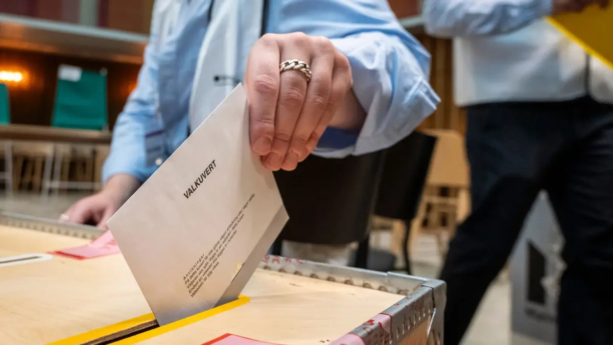 Parlamentswahl in Schweden: 13.09.2026, Schweden, Malmö: Eine Wählerin wirft in einem Wahllokal im Rathaus von Malmö ein Wahlumschlag in eine Wahlurne. Foto: Johan Nilsson/TT News Agency via AP/dpa +++ dpa-Bildfunk +++