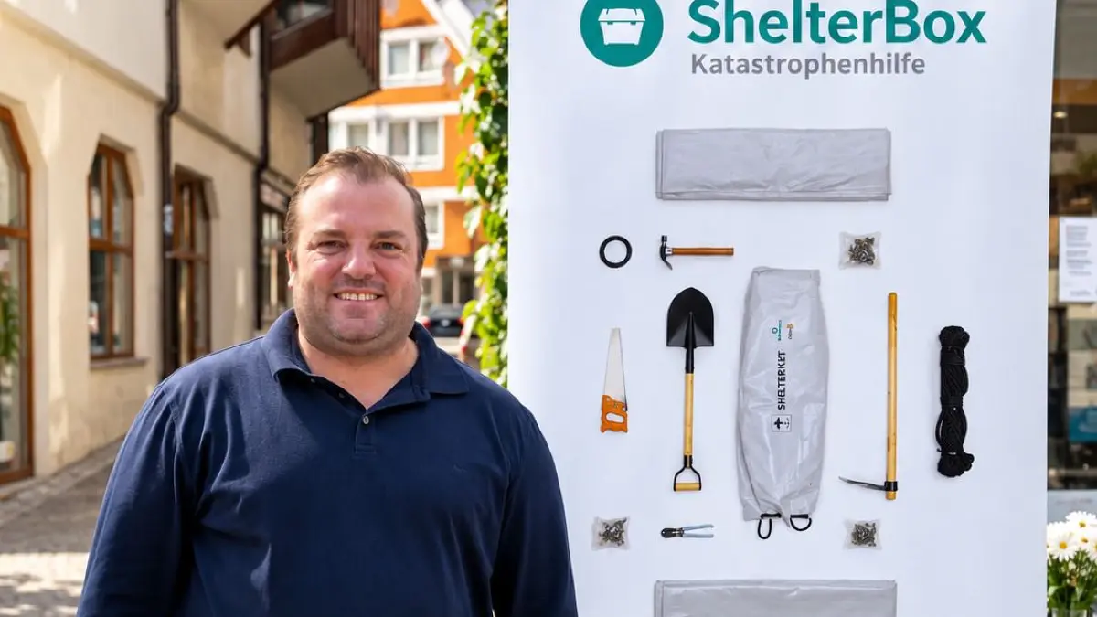 Benjamin Jetter vor dem Plakat ShelterBox.